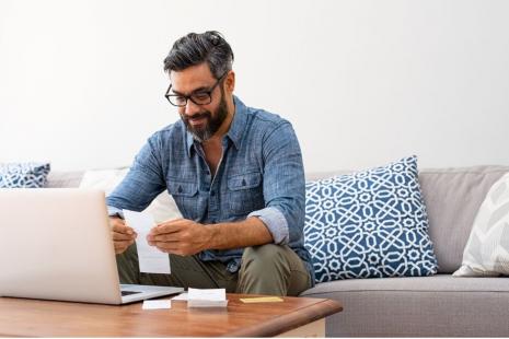 Image of man sitting with laptop at coffee table